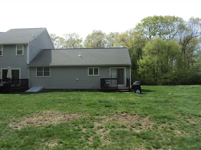 back of house featuring a lawn and a wooden deck