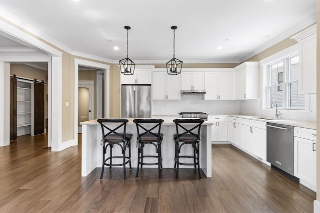 30 Southfield Ln Unit 30, Sherborn, MA 01770 - kitchen featuring appliances with stainless steel finishes, a sink, a kitchen island, decorative backsplash, and light countertops