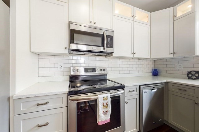 1834 Beacon St Unit 16, Brookline, MA 02445 - kitchen with stainless steel appliances, backsplash, glass insert cabinets, and white cabinets