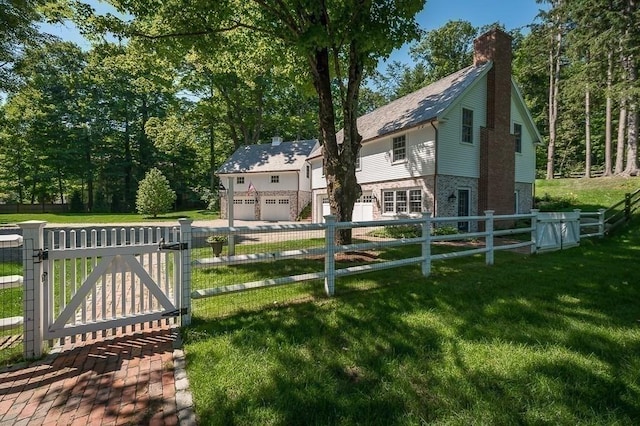 view of yard featuring a gate, fence private yard, and a garage