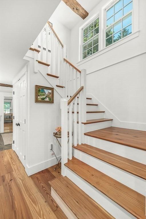 staircase with wood finished floors and baseboards