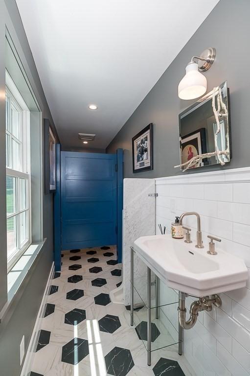 bathroom with a sink and tile walls