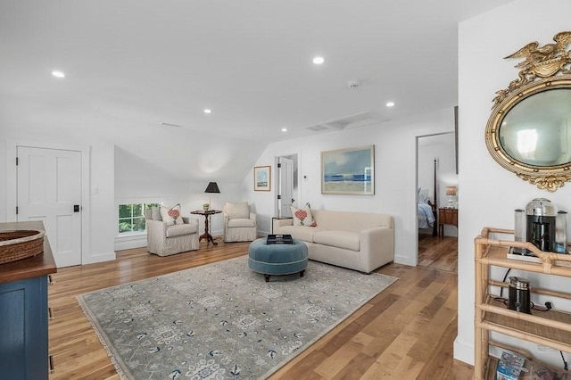 living room with lofted ceiling, light wood-style flooring, and recessed lighting