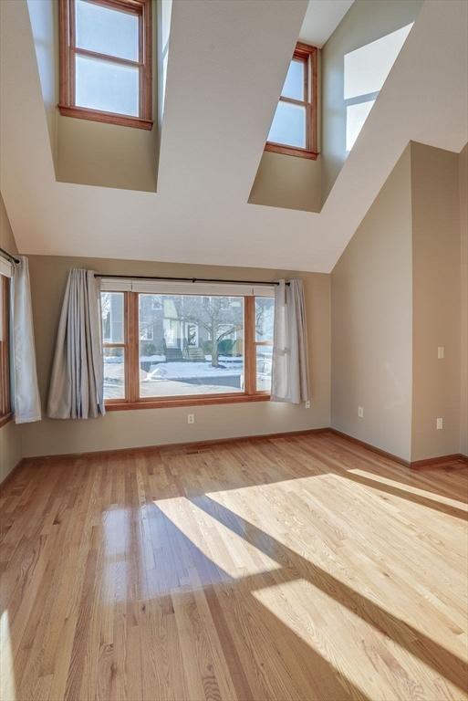 additional living space with high vaulted ceiling and light hardwood / wood-style flooring