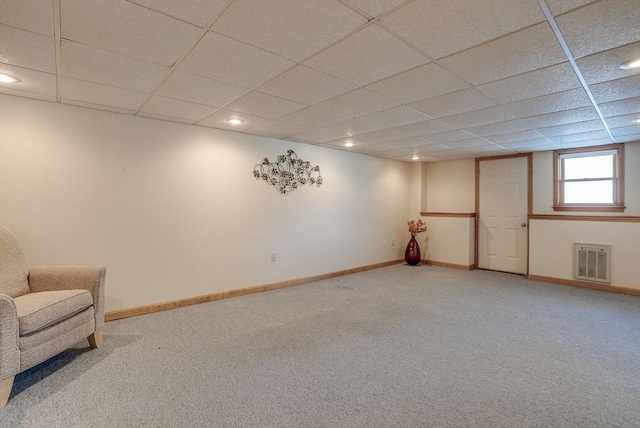 basement featuring a paneled ceiling and carpet