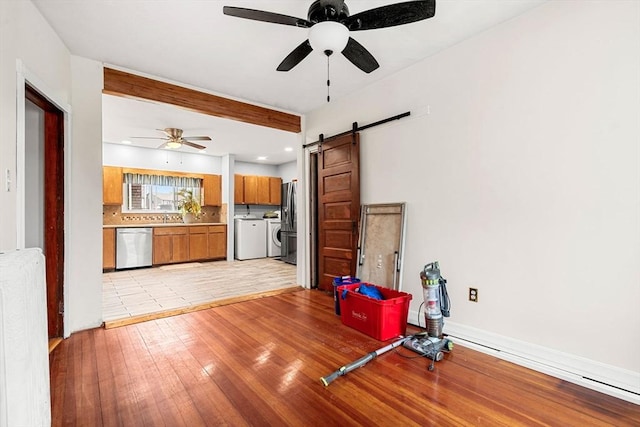 26 Enfield Rd, Winthrop, MA 02152 - living area with washer and dryer, a ceiling fan, a barn door, light wood-style flooring, and recessed lighting