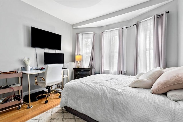 26 Enfield Rd, Winthrop, MA 02152 - bedroom with wood finished floors, radiator, and an office area