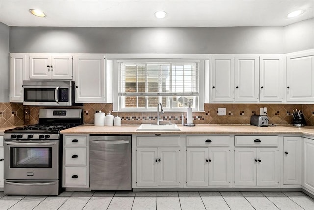 26 Enfield Rd, Winthrop, MA 02152 - kitchen featuring appliances with stainless steel finishes, light countertops, tasteful backsplash, white cabinets, and recessed lighting