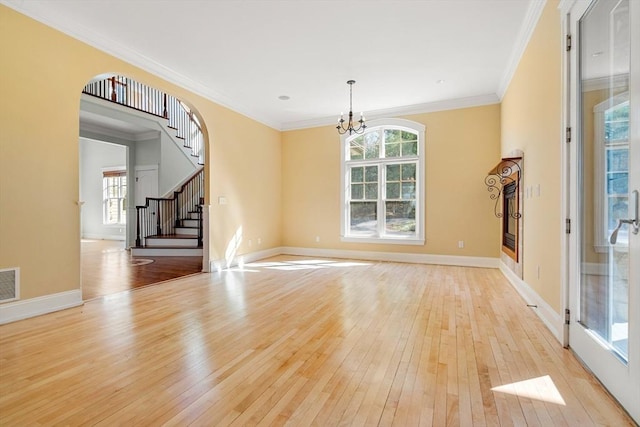 unfurnished living room with a notable chandelier, visible vents, baseboards, light wood-style floors, and stairs
