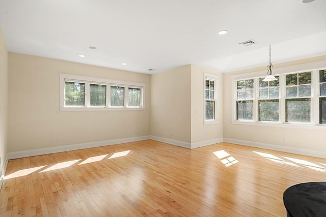 unfurnished living room with baseboards, visible vents, and plenty of natural light
