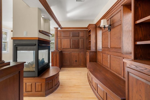 mudroom featuring a multi sided fireplace, light wood-type flooring, and visible vents