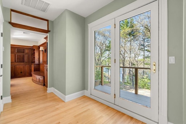 entryway with visible vents, light wood-style flooring, and baseboards