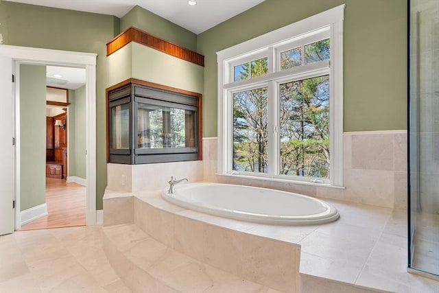 bathroom with tile patterned floors and a bath