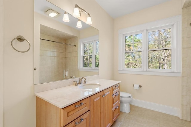 bathroom featuring vanity, toilet, baseboards, and tiled shower