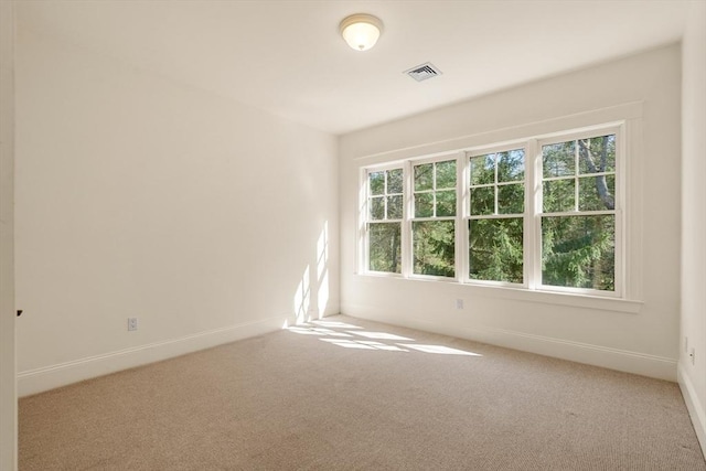 carpeted spare room with baseboards and visible vents