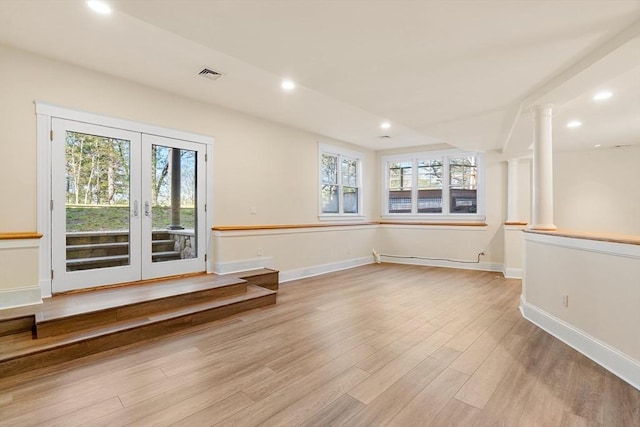 empty room with recessed lighting, visible vents, decorative columns, and wood finished floors