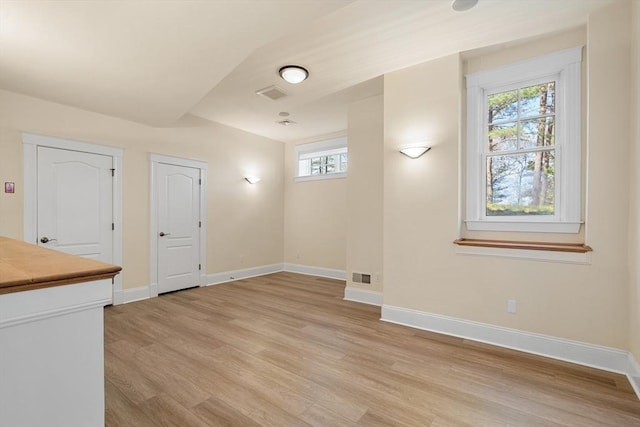 interior space with baseboards, visible vents, and light wood-style floors