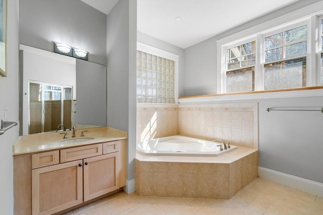 bathroom with vanity, a garden tub, a healthy amount of sunlight, and tile patterned floors