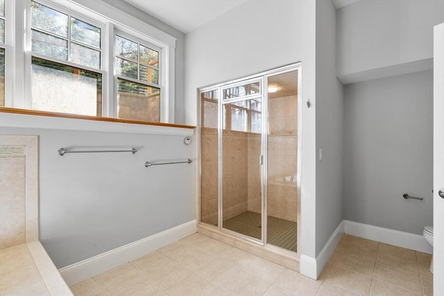 full bath featuring a stall shower, tile patterned flooring, toilet, and baseboards