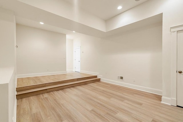 empty room with baseboards, light wood-style floors, and recessed lighting