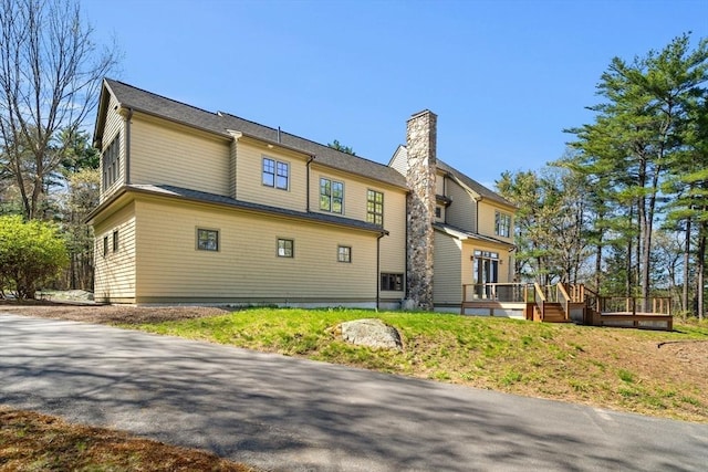 rear view of house with a wooden deck and a chimney
