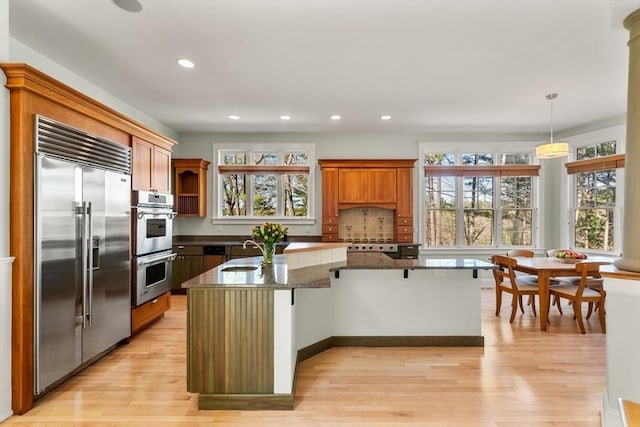 kitchen featuring recessed lighting, light wood-style floors, appliances with stainless steel finishes, and a sink