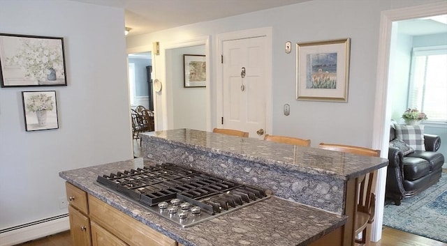 6 Jeffrey Ln, Freetown, MA 02702 - kitchen with a baseboard heating unit, stainless steel gas cooktop, a center island, dark stone countertops, and wood finished floors