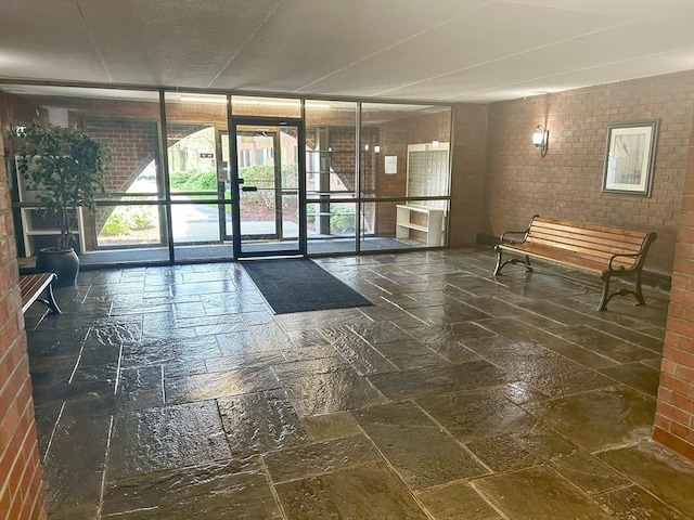 building lobby with brick wall and floor to ceiling windows