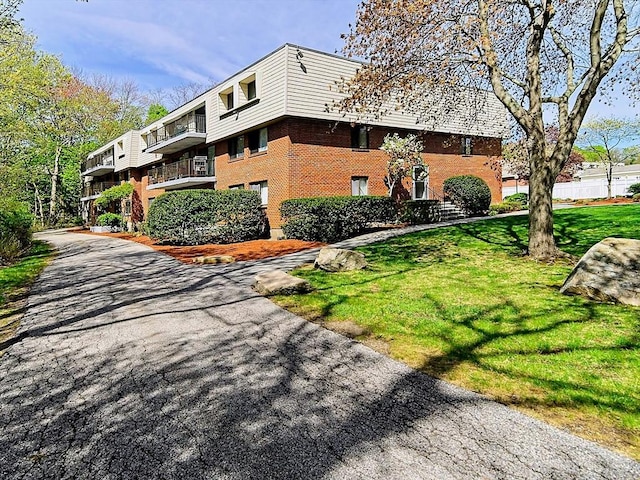 view of side of property with a yard and brick siding