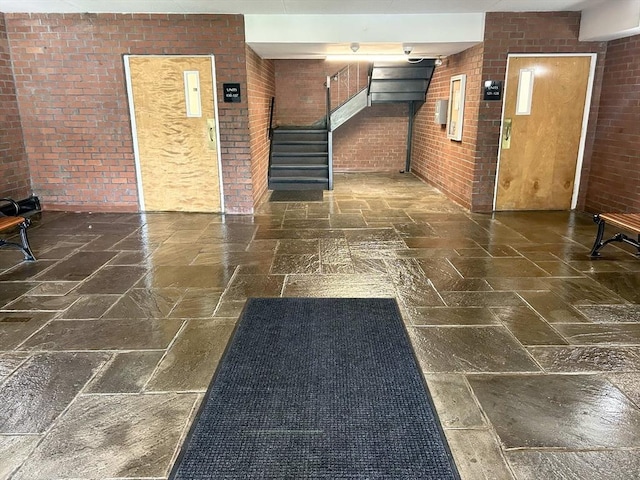 lobby featuring brick wall and stairs