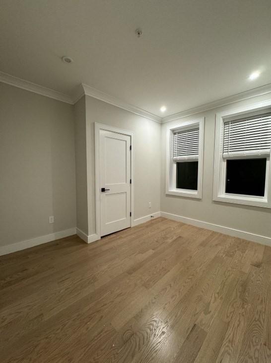 unfurnished room featuring hardwood / wood-style floors and ornamental molding