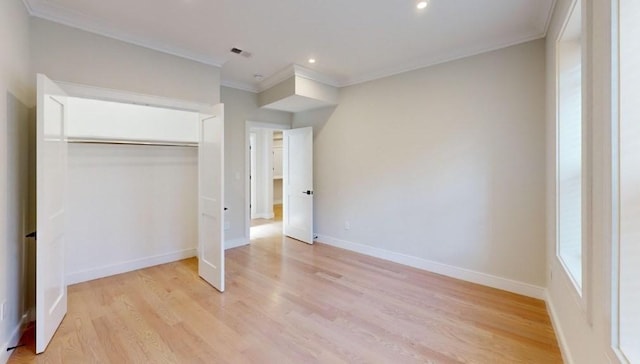 unfurnished bedroom with a closet, ornamental molding, and light hardwood / wood-style flooring