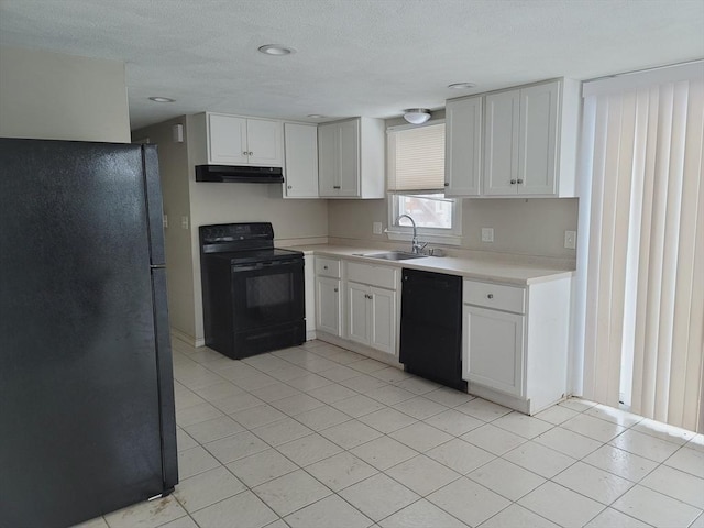 kitchen with under cabinet range hood, a sink, white cabinets, light countertops, and black appliances