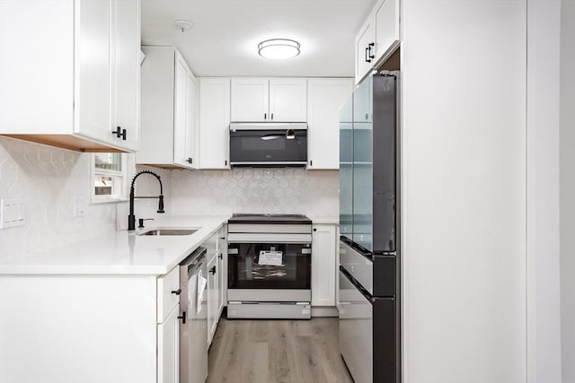22 Frenier Ave Unit 9, Attleboro, MA 02703 - kitchen with stainless steel appliances, a sink, light wood-style flooring, and white cabinetry