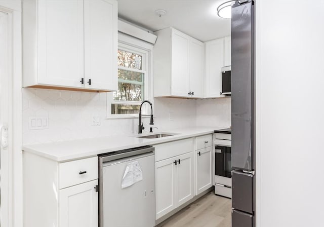 22 Frenier Ave Unit 9, Attleboro, MA 02703 - kitchen featuring dishwashing machine, white cabinets, backsplash, a sink, and light countertops