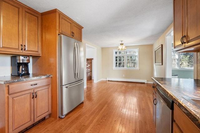 kitchen featuring stainless steel appliances, baseboard heating, and light hardwood / wood-style flooring