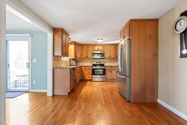 kitchen featuring appliances with stainless steel finishes, light stone countertops, and decorative backsplash