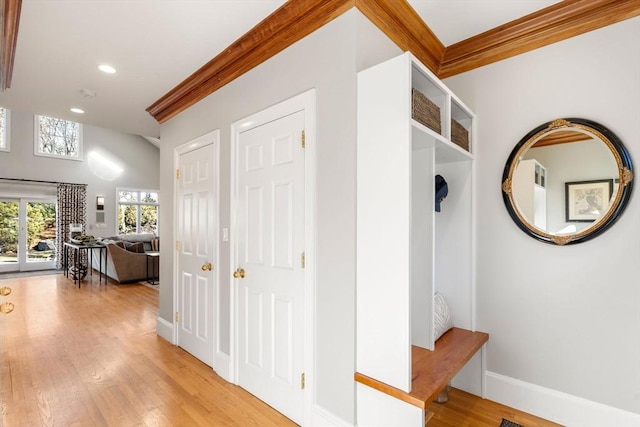 hallway featuring light wood-style floors, recessed lighting, crown molding, and baseboards