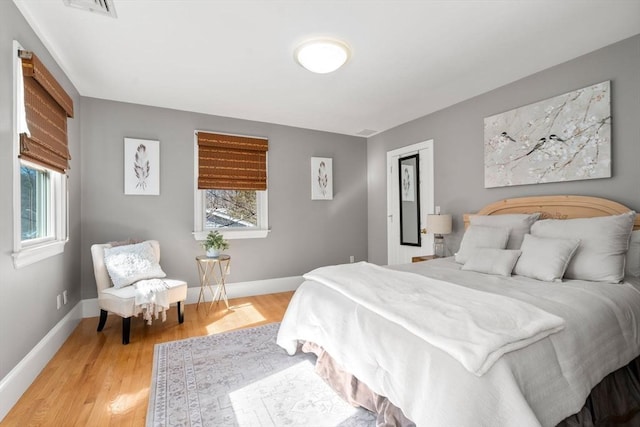 bedroom featuring baseboards, visible vents, and light wood-style floors