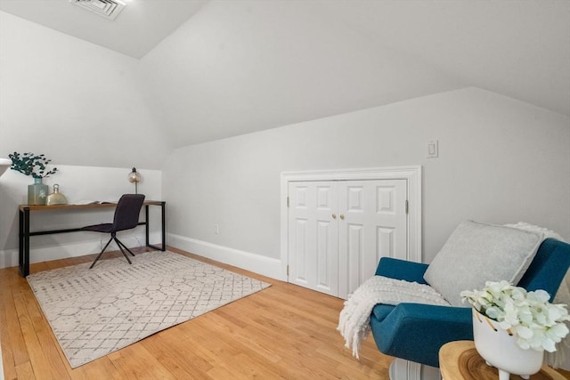 office featuring lofted ceiling, wood finished floors, visible vents, and baseboards