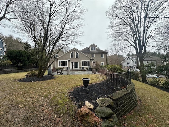 back of property with a yard and a patio area