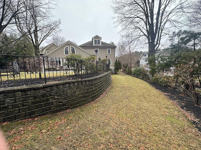 back of house featuring fence and a yard