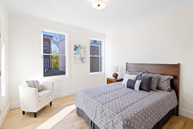 bedroom with light wood-type flooring and crown molding