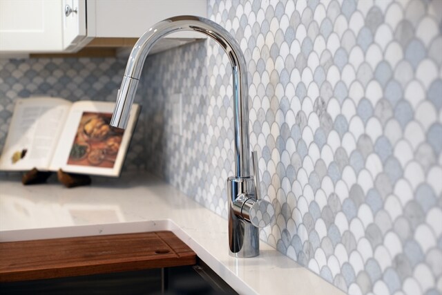 details featuring decorative backsplash and white cabinetry