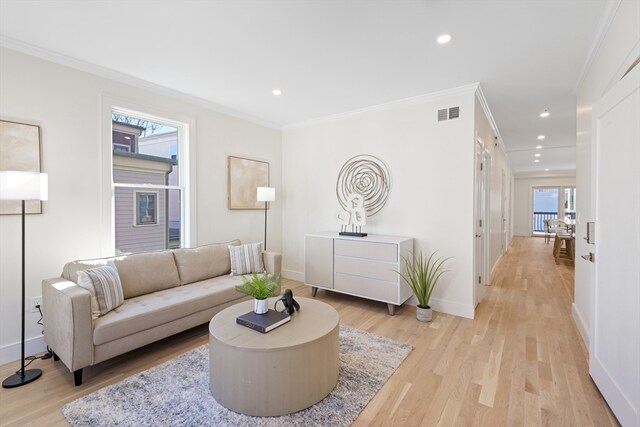 living room featuring light wood-type flooring and ornamental molding