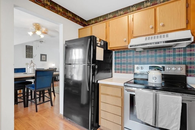 42 Nassau Dr Unit 42, Springfield, MA 01129 - kitchen with stainless steel electric stove, freestanding refrigerator, extractor fan, light countertops, and light wood-style floors