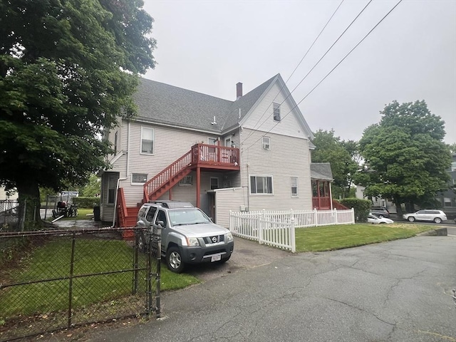 2 Stanton St, Boston, MA 02124 - view of front of home featuring a chimney, stairway, and roof with shingles