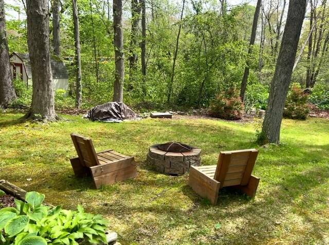 view of green lawn with a fire pit