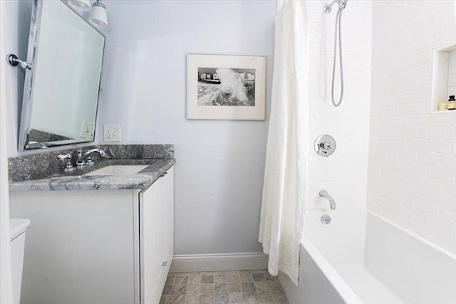 bathroom with toilet, vanity, baseboards, and shower / bathtub combination with curtain