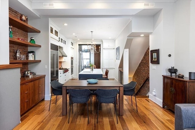 dining area with baseboards, visible vents, an inviting chandelier, light wood-style flooring, and stairs